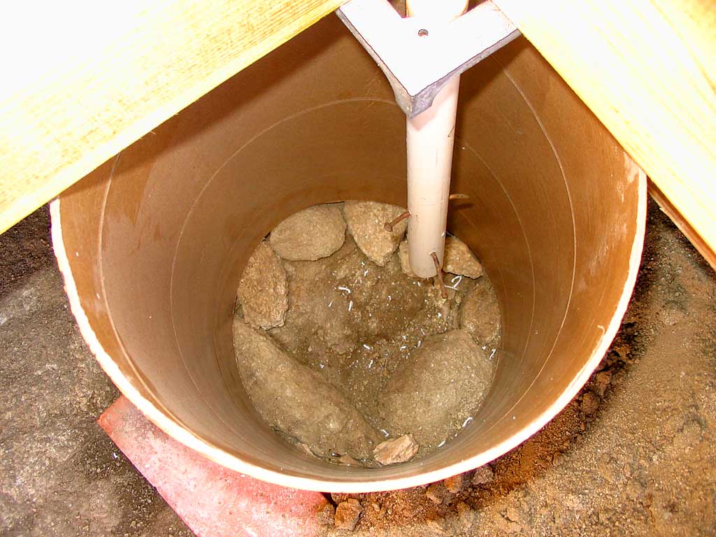 The sono tube is in place and the soil is wet. Excess gaps are plugged.