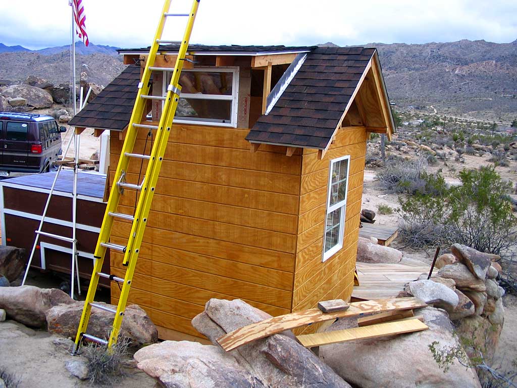 Two T1-11 panels and a window have been nailed to the north side