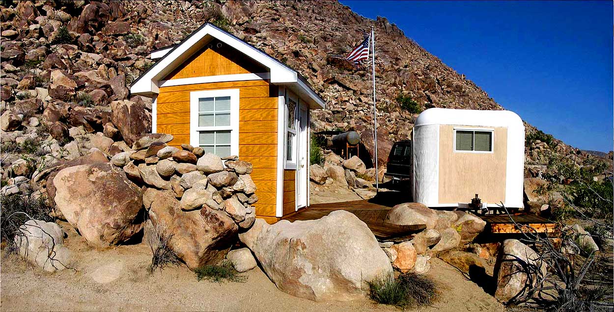 Composite of shed, deck, box trailer, water tubs & tank, van, house trailer