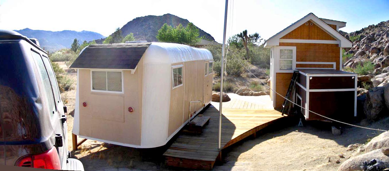 An overview of the completed shed exterior, deck and trailers